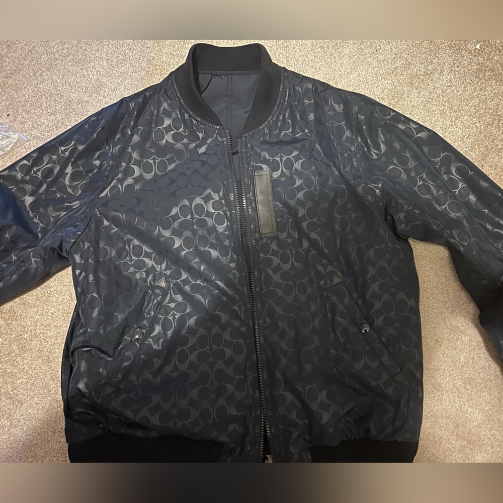 Men’s black Coach flight jacket. Signature C’s on outside. All black inside.